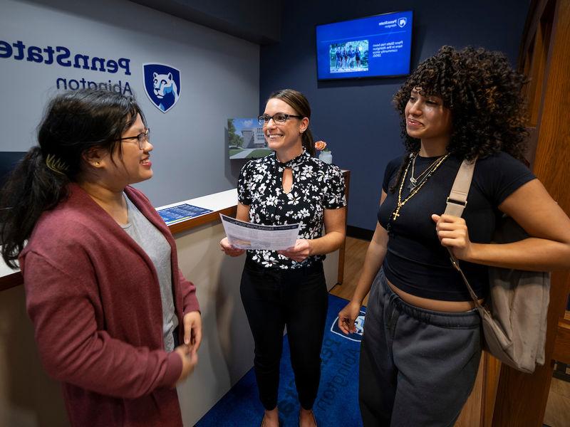 two students talking with financial aid staff 